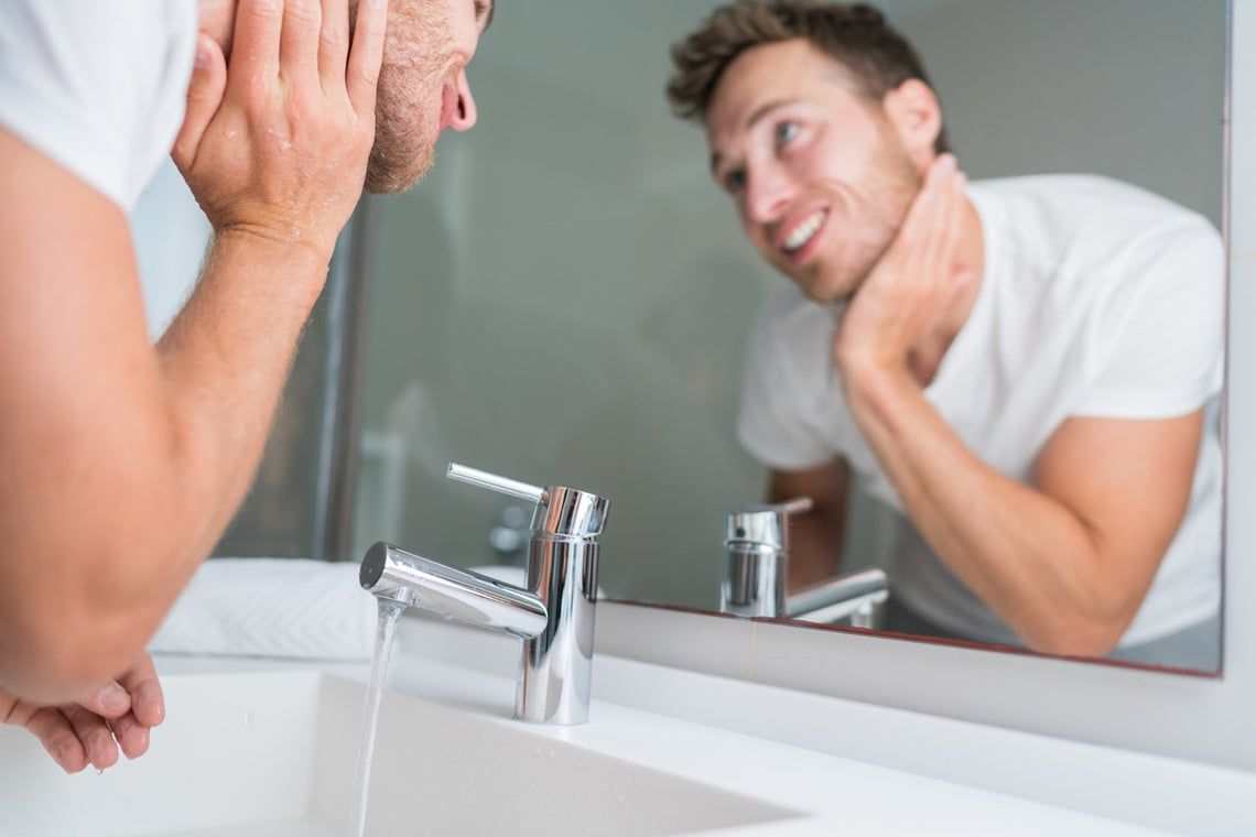 Man using moisturizer over the bathroom sink