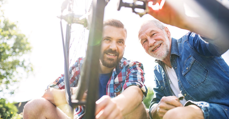 Elderly Father and Middle Aged Son working on bike