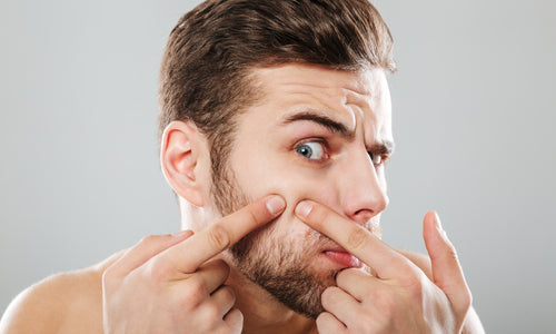 man squeezing blemish