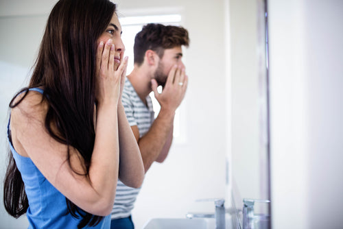 couple checking skin in mirror