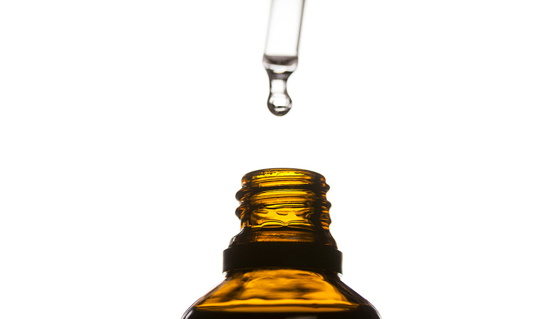 Eyedropper drips serum into bottle