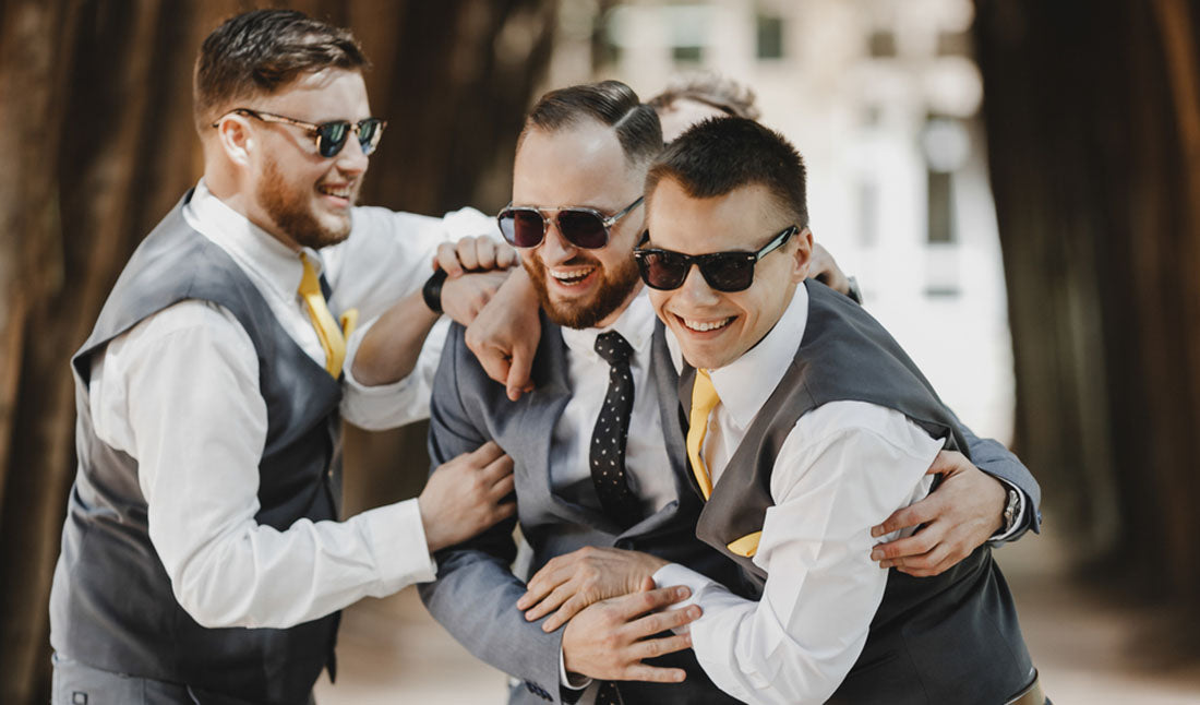 groomsmen embracing and laughing