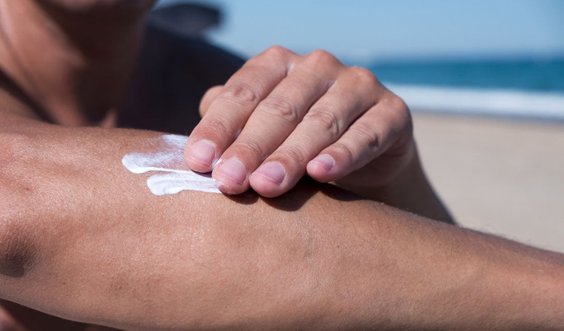 man applying sunscreen to forearm