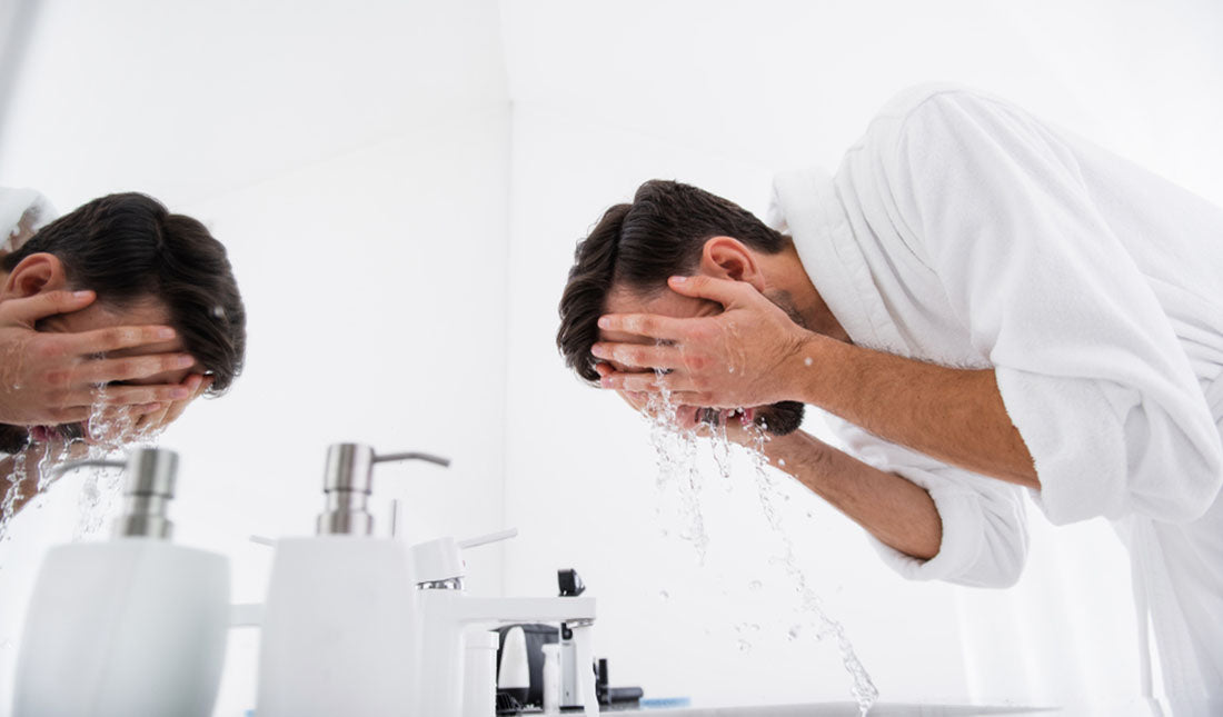 man bending to wash face