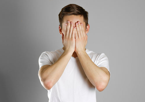 man covering face with hands