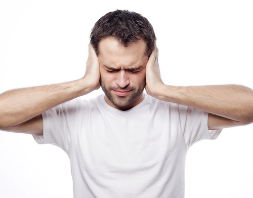 man holding hands over ears