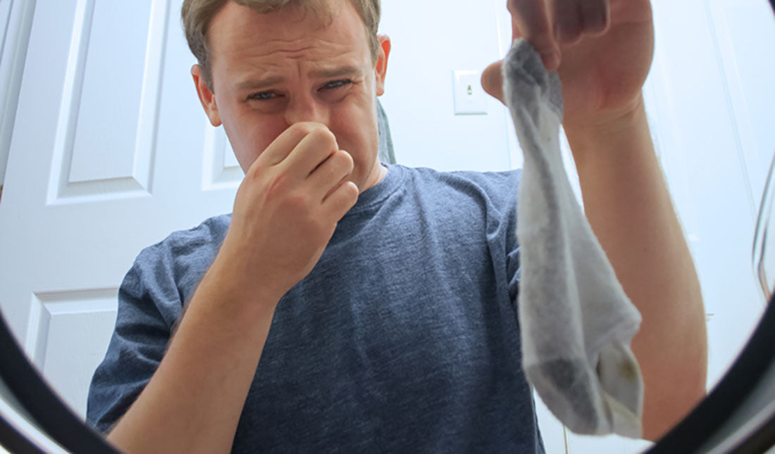 man holding smelly sock
