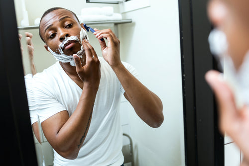 man shaving in mirror