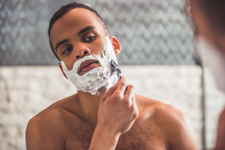 man shaving with razor and cream