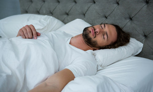 man sleeping on his bed
