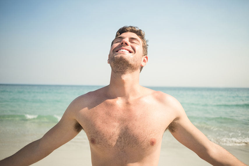 man smiling at camera on beach
