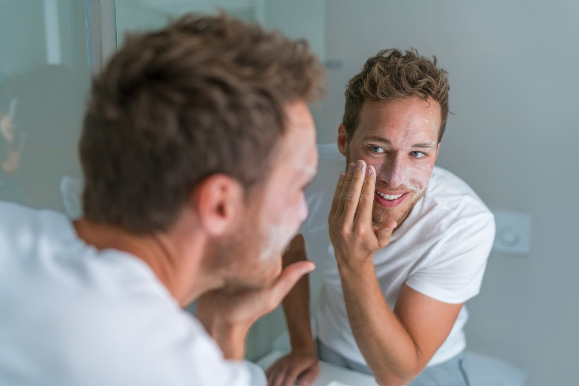 Man washing his face with a foaming exfoliating scrub