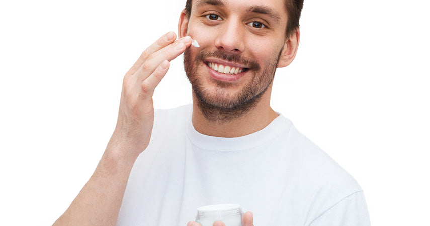 man using jar of cream on face