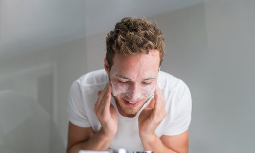 man washing face with facial cleanser