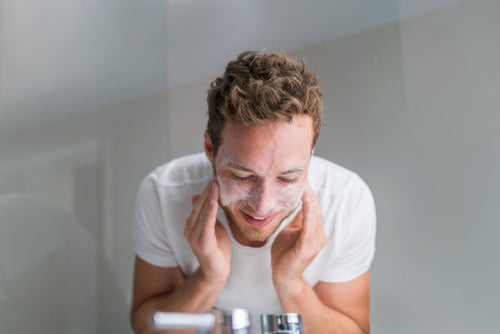 man washing face with facial cleanser