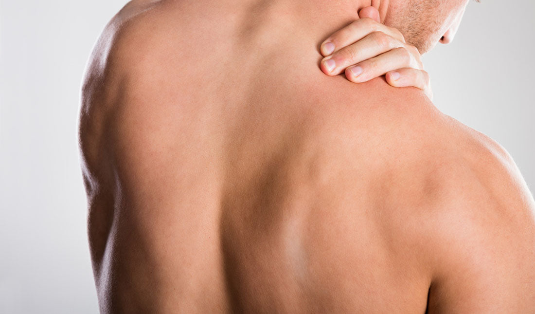 shirtless man massaging shoulder