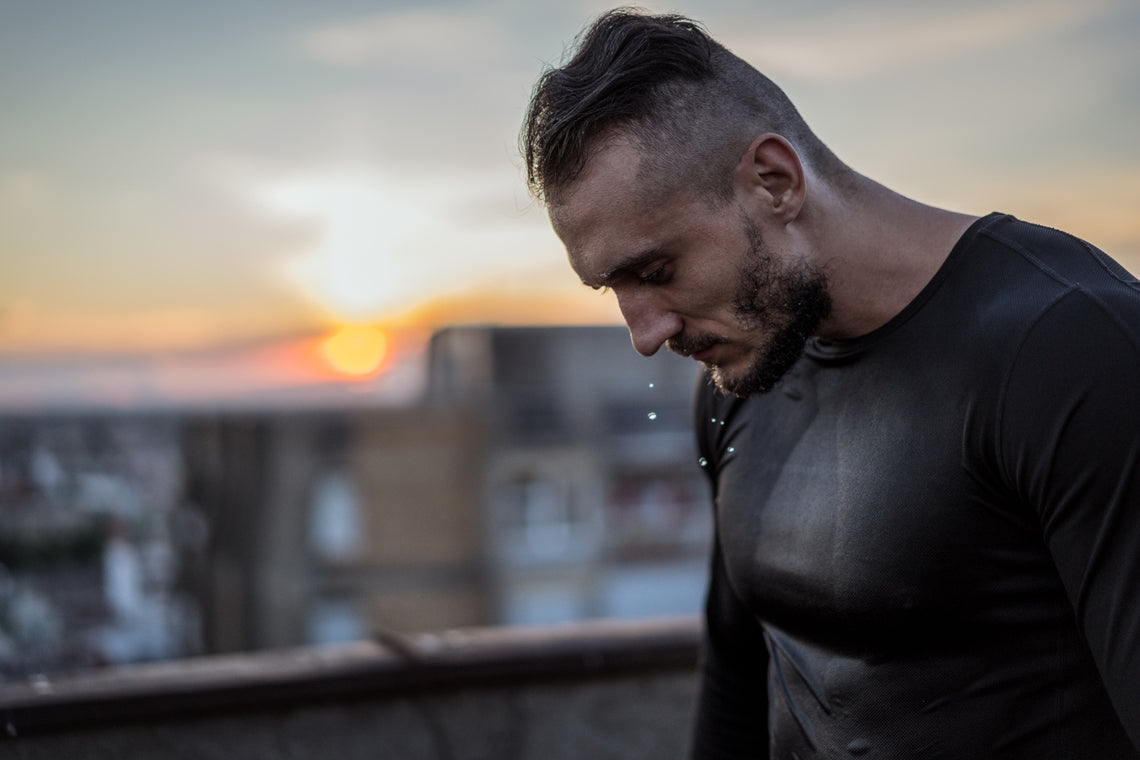 Sweaty male athlete with sunrise in the background