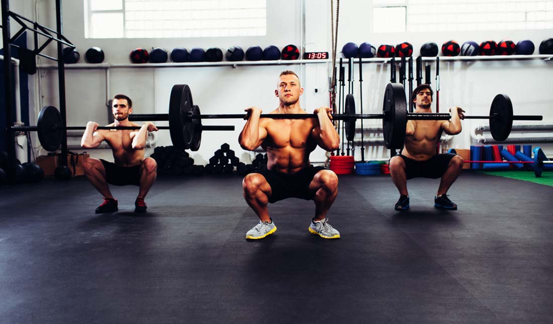 trio of men doing squats with weights