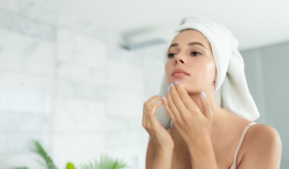 woman wearing towel checking reflection