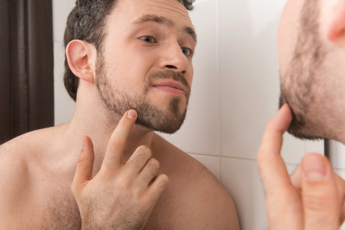 young man examining his stubble