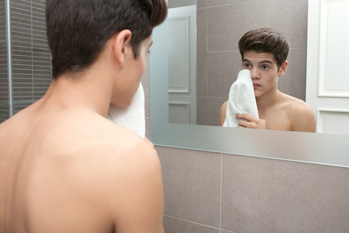young man washing his face